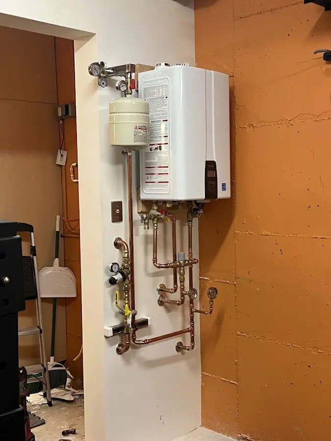 Plumbing technician inspecting water heater connections in Holiday